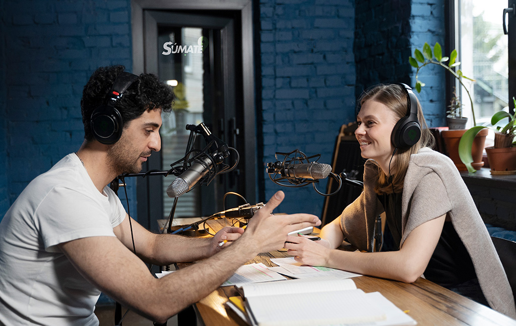 dos personas hablando a traves de un microfono